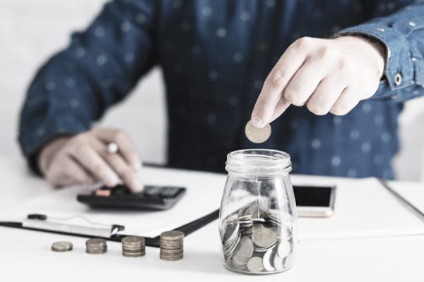 close-up-man-s-hand-putting-coin-jar-using-calculator_23-2147892280